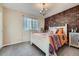 Bright bedroom with a white bed frame, brick accent wall, and decorative chandelier at 11710 Crow Hill Dr, Parker, CO 80134