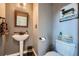 Cozy powder room with pedestal sink, toilet, and rustic-themed decor at 11710 Crow Hill Dr, Parker, CO 80134