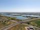 Scenic aerial view featuring a complex of tranquil lakes, lush green fields, and a winding highway system at 14025 Florence Ct, Brighton, CO 80602