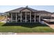 Sprawling backyard featuring a lush lawn, large covered porch, and second-story balcony, ideal for entertaining at 14025 Florence Ct, Brighton, CO 80602