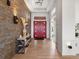 Grand foyer with a stacked stone accent wall, console table, and double red doors at 14025 Florence Ct, Brighton, CO 80602