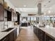 Gourmet kitchen featuring dark cabinets, white countertops, and stainless steel appliances open to the dining area at 14025 Florence Ct, Brighton, CO 80602