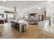 Open kitchen flows to living area, features a large island, modern lighting, and upscale appliances at 14025 Florence Ct, Brighton, CO 80602