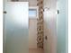 Modern shower showcasing gray tiling with mosaic accents and frameless glass doors at 14025 Florence Ct, Brighton, CO 80602