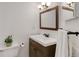 Cozy bathroom featuring modern fixtures, wood vanity, framed mirror, and decorative accents at 12486 W Nevada Pl # 106, Lakewood, CO 80228