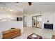 Bright living room featuring a fireplace, modern lighting, and a view into the updated kitchen at 12486 W Nevada Pl # 106, Lakewood, CO 80228