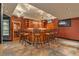 Basement bar area with seating for ten, custom lighting, and a large countertop at 3873 Fairbrook Pt, Highlands Ranch, CO 80130