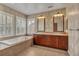 Bathroom features tiled floor, soaking tub and and sinks with wooden cabinets at 3873 Fairbrook Pt, Highlands Ranch, CO 80130