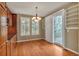 Dining area featuring wood floors, a chandelier, and doors leading to the outdoor balcony at 3873 Fairbrook Pt, Highlands Ranch, CO 80130