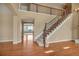 Elegant home entryway with hardwood floors, staircase, and arched doorway leading to spacious living area at 3873 Fairbrook Pt, Highlands Ranch, CO 80130