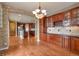 Open-concept kitchen boasts dark cabinetry, black countertops, and hardwood floors throughout the connecting rooms at 3873 Fairbrook Pt, Highlands Ranch, CO 80130