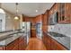 Fully equipped kitchen with island, gas range, stainless appliances, and dark wood cabinetry at 3873 Fairbrook Pt, Highlands Ranch, CO 80130