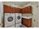Well-equipped laundry room with a washer, dryer, sink, and wooden cabinets at 3873 Fairbrook Pt, Highlands Ranch, CO 80130