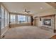 Comfortable living room featuring a fireplace with stone surround, plush carpeting, and a view at 3873 Fairbrook Pt, Highlands Ranch, CO 80130