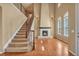 Bright open living room with soaring ceilings, fireplace, large windows and adjacent staircase at 3873 Fairbrook Pt, Highlands Ranch, CO 80130