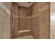 Contemporary shower with brown tile surround and built-in bench at 3873 Fairbrook Pt, Highlands Ranch, CO 80130