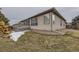 Backyard featuring partial snow cover, landscaping, and a view of the home's exterior at 17423 Cornerstone Ln, Parker, CO 80134