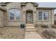 Inviting front entrance with a decorative door, manicured landscaping, and stone walkway at 17423 Cornerstone Ln, Parker, CO 80134