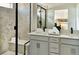 Modern bathroom featuring a double vanity, black hardware, and a walk-in shower with bench at 6601 E 148Th Dr, Thornton, CO 80602