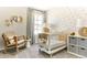 Cozy Bedroom featuring a white crib, rocking chair, bee themed wallpaper, and soft natural lighting at 6601 E 148Th Dr, Thornton, CO 80602