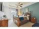 Cozy bedroom features a tray ceiling, a ceiling fan, and a sliding glass door to the outside at 22932 E Ontario Dr # 102, Aurora, CO 80016