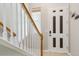 Bright entryway featuring tile floors, staircase with white and wood banister, and a stylish front door at 22932 E Ontario Dr # 102, Aurora, CO 80016