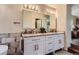 Bright bathroom with a granite-topped double sink vanity with white cabinetry and modern fixtures at 8807 Tuscany Ln, Highlands Ranch, CO 80130
