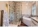 Beautifully designed bathroom with standalone tub and tiled glass shower with rain shower head and stone flooring at 8807 Tuscany Ln, Highlands Ranch, CO 80130
