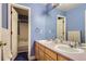 Blue bathroom with a double sink vanity, a mirror, and a view into a tub and shower combo room at 8807 Tuscany Ln, Highlands Ranch, CO 80130