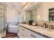 A modern bathroom featuring granite counters, dual sinks, a standalone tub, and a glass shower, with stylish hanging lights at 8807 Tuscany Ln, Highlands Ranch, CO 80130