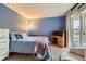 Bedroom featuring a blue accent wall, a comfy bed, wooden desk, and sliding glass door to a patio at 8807 Tuscany Ln, Highlands Ranch, CO 80130