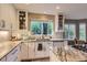 Bright kitchen featuring white cabinets, granite countertops, and a view of the outside at 8807 Tuscany Ln, Highlands Ranch, CO 80130