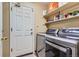 Laundry room features modern washer and dryer, along with ample shelving for storage at 8807 Tuscany Ln, Highlands Ranch, CO 80130