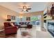 Cozy living room featuring a ceiling fan, fireplace, and backyard access via sliding glass door at 8807 Tuscany Ln, Highlands Ranch, CO 80130