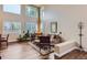 Open-concept living room featuring tall ceilings, large windows, and hardwood floors at 8807 Tuscany Ln, Highlands Ranch, CO 80130