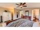 Comfortable main bedroom featuring a ceiling fan, a dresser with a mirror, and an attached bathroom with a standalone bathtub at 8807 Tuscany Ln, Highlands Ranch, CO 80130