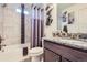 Modern bathroom featuring a shower-tub combo with decorative tile surround and granite countertop vanity at 19118 E 54Th Pl, Denver, CO 80249