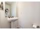 Clean half-bathroom with a pedestal sink, modern fixtures, and a simple mirror at 19118 E 54Th Pl, Denver, CO 80249