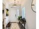Bright foyer featuring a decorative rug, coat rack, bench with plants, and a modern pendant light at 19118 E 54Th Pl, Denver, CO 80249