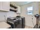 Bright laundry room featuring newer machines, storage cabinets, shelves and a window for natural light at 19118 E 54Th Pl, Denver, CO 80249