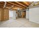 Unfinished basement with exposed wooden ceiling and walls, revealing the infrastructure with an open door to a finished space at 6294 Long Branch Dr, Parker, CO 80134