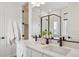 Bright bathroom featuring a double vanity, quartz countertops, and a glass-enclosed shower with white subway tiles at 6294 Long Branch Dr, Parker, CO 80134