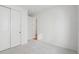 Minimalist bedroom showcasing neutral carpet and white walls, with closet and doorway leading to another space at 6294 Long Branch Dr, Parker, CO 80134