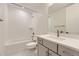 Clean bathroom featuring a shower-tub combo, updated vanity, and a white tile surround at 11454 Stonewash St, Littleton, CO 80125