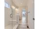 This modern shower features a glass door, tiled walls, bench seat, and neutral design at 11454 Stonewash St, Littleton, CO 80125