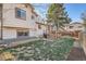 Spacious backyard featuring a wooden deck, stone retaining wall, and lush green lawn at 2210 S Oakland Way, Aurora, CO 80014