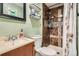 Cozy bathroom features tiled shower with shower caddy, wall storage and decorative sink at 2210 S Oakland Way, Aurora, CO 80014