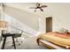 Serene bedroom with a ceiling fan, soft lighting, and a workspace by the window, designed for relaxation and productivity at 2210 S Oakland Way, Aurora, CO 80014