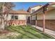 Well-maintained home featuring brick accents, a covered porch, and a neatly manicured lawn at 2210 S Oakland Way, Aurora, CO 80014