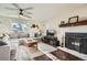 Comfortable living room featuring a fireplace, ceiling fan, and a large window at 2210 S Oakland Way, Aurora, CO 80014